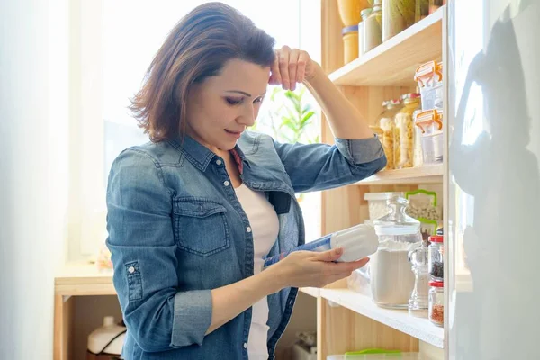 食品杂货店里的妇女，厨房里储存食物的木架 — 图库照片