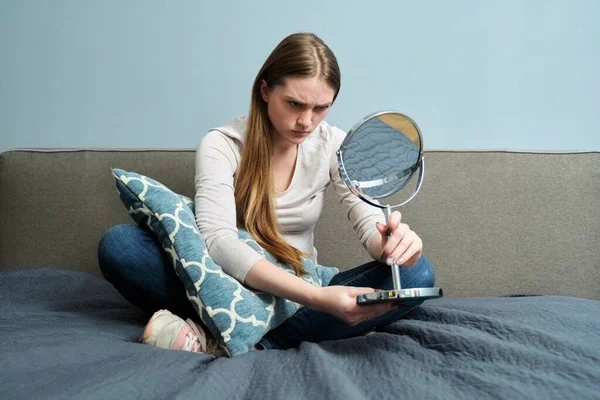 Красива молода жінка з дзеркалом для макіяжу сидить вдома в ліжку — стокове фото