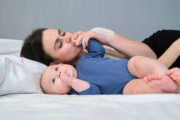 Fiatal Anya Szeretettel Megcsókolja Kisfiát Játszik Babával Miközben Fekszik Ágyban — Stock Fotó