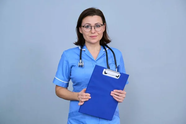 Retrato Enfermeira Madura Segurando Prancheta Feminino Uniforme Azul Com Estetoscópio — Fotografia de Stock