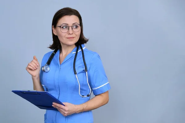 Retrato Enfermeira Madura Segurando Prancheta Feminino Uniforme Azul Com Estetoscópio — Fotografia de Stock