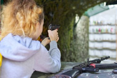 Atış poligonunda atış talimi yapan genç kızın yakın çekimi..