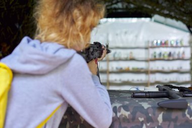 Atış poligonunda eğitim tüfeği kullanan genç bir kızın yakın çekimi..