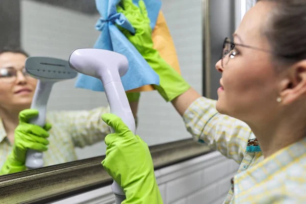 청소를 여자들은 가정용 약품을 사용하지 진공소제기를 거울에 증기로 장갑낀 클로즈업 — 스톡 사진
