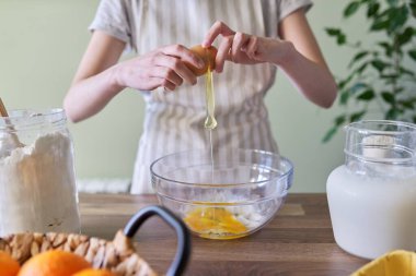 Yumurtayı kasede kırmaya yakın çekim, krep için hamur hazırlamak..