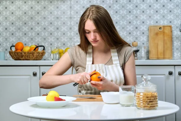 Молодая Красивая Женщина Фруктами Кухне Женщина Сидит Столом Чистит Апельсин — стоковое фото