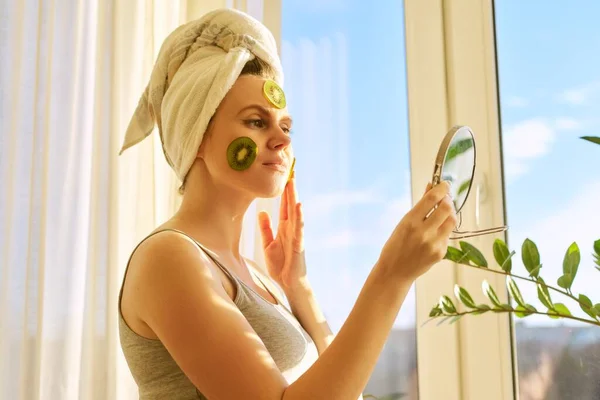 Smilende Ung Vakker Kvinne Nærheten Vinduet Med Naturlig Hjemmelaget Ansiktsmaske – stockfoto