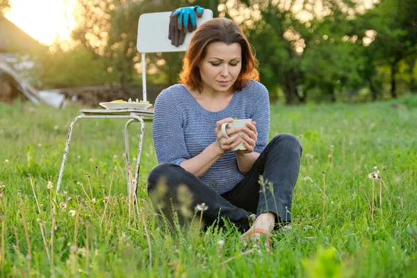 Szczęśliwy Piękny Dojrzały Kobieta Ogrodnik Spoczywa Trawie Filiżanką Naturalnej Herbaty — Zdjęcie stockowe