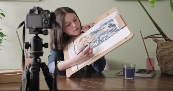 Suluboya resimli ergen kız, evde masada oturuyor. Sanat, eğitim, yaratıcılık, gençlik hobileri — Stok video