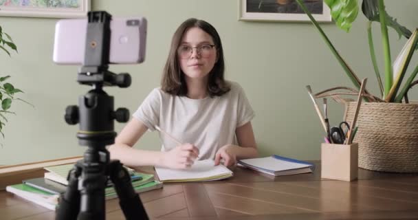 Teenagermädchen lernt online mit Smartphone, hört zu und spricht auf Videokonferenz