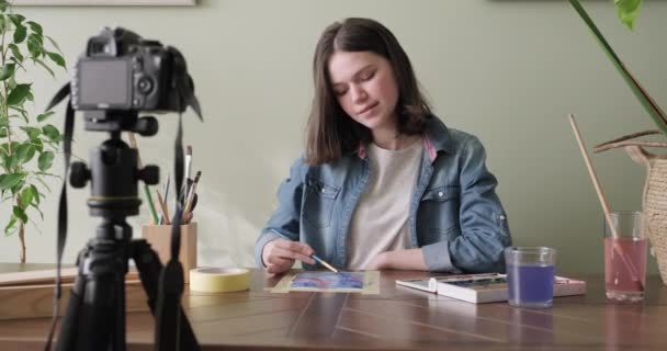 Artista, adolescente, desenha e grava em câmera de vídeo para seu blog — Vídeo de Stock