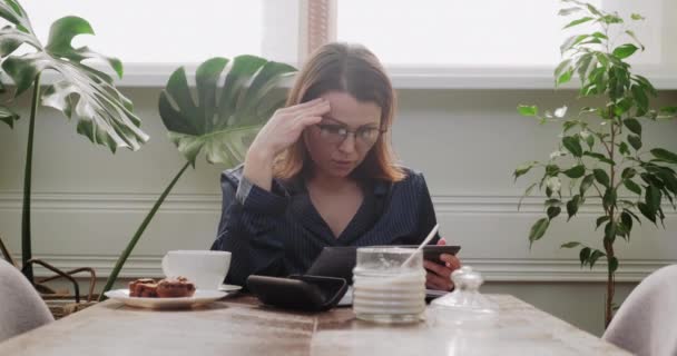 Snídaně zralá žena v pyžamu s šálkem čaje čtení digitální tablet, špatné zprávy — Stock video