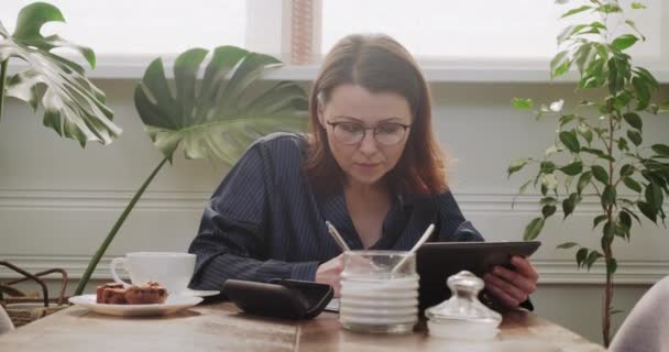 Tableta digital de lectura femenina, escritura en cuaderno de negocios, trabajo remoto — Vídeo de stock