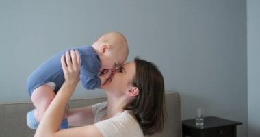 Mutlu bir anne ve bebek, genç ve güzel bir annenin kollarında bir çocuk.