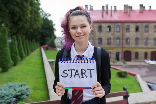 Teenager girl holding notepad with word start. Zpátky do školy, zpátky na vysokou. — Stock fotografie