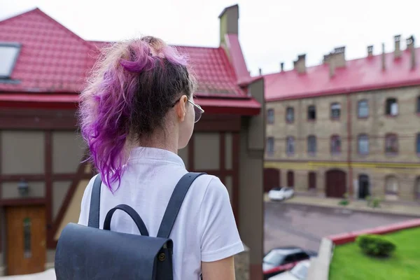 Portrét dospívající dívky s batohem stojící vzadu při pohledu na školní budově — Stock fotografie