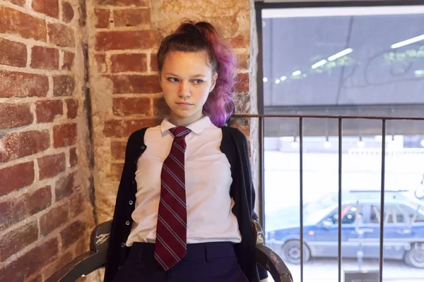 Портрет 15-річної дівчинки-підлітка в шкільній формі з краваткою, що сидить на стільці — стокове фото