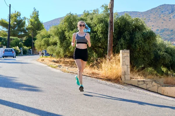 Girl teenager runner, female running on mountain road — Stock Photo, Image