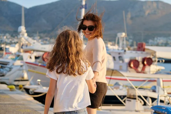 Mutlu anne ve kız çocuğu deniz kenarında el ele yürüyorlar. — Stok fotoğraf