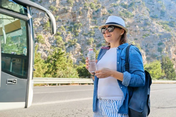 高速道路の山の中で水のボトルと帽子の女性 — ストック写真