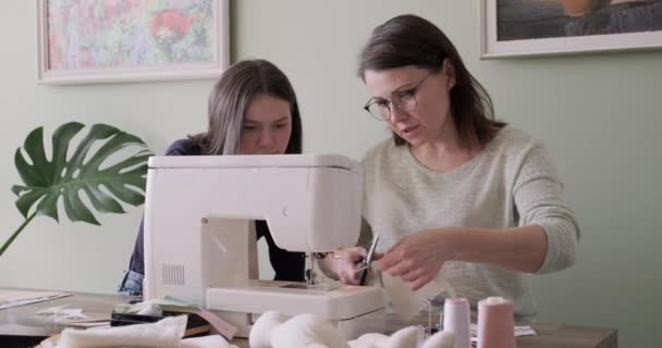 Maman enseignant fille couture sur machine, les femmes cousent jouet et vêtements pour jouet — Video