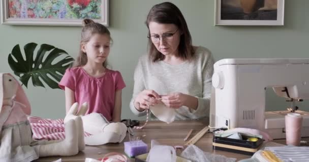 Glückliche Mutter und Tochter nähen Spielzeug-Hasenpuppe zu Hause zusammen — Stockvideo