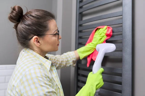 Woman cleaning heated towel rail, using steam machine — Stock Photo, Image