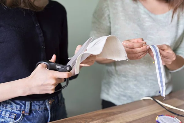 Proceso de costura de cerca. Las manos de la mujer y la hija de coser — Foto de Stock