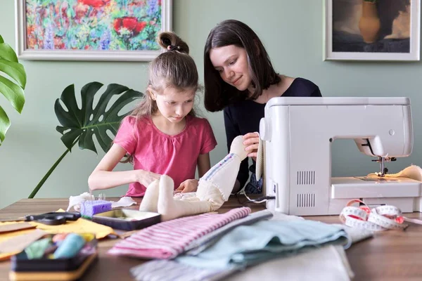 Familia, dos niñas hermanas adolescente y más joven juntos coser juguete muñeca conejito — Foto de Stock