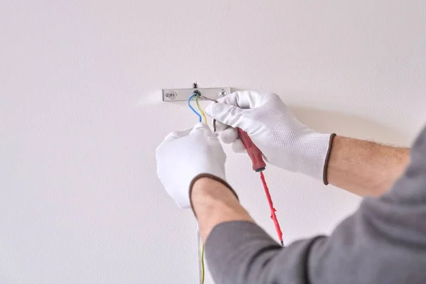 Detailní záběr rukou elektrikáře instalujícího nástěnnou lampu — Stock fotografie