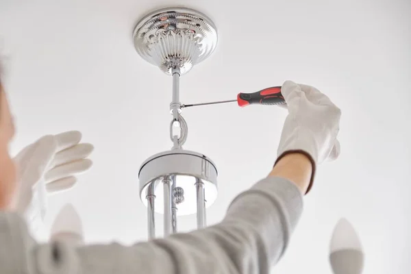 Instalação lâmpada de teto, mãos de eletricista fixando lustre — Fotografia de Stock