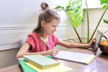 Dijital tablet kullanan kız çocuğu evde çalışıyor