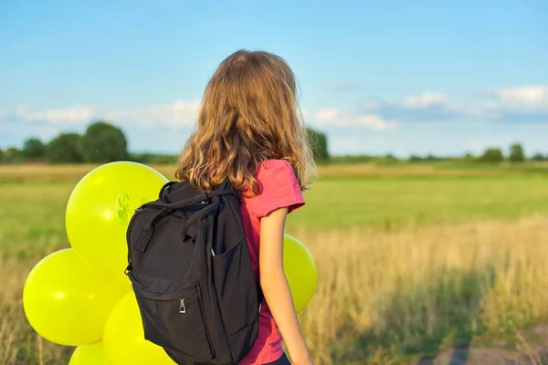 Kid girl with backpack balloons running on country road, rear view, copy space — Stock Photo, Image