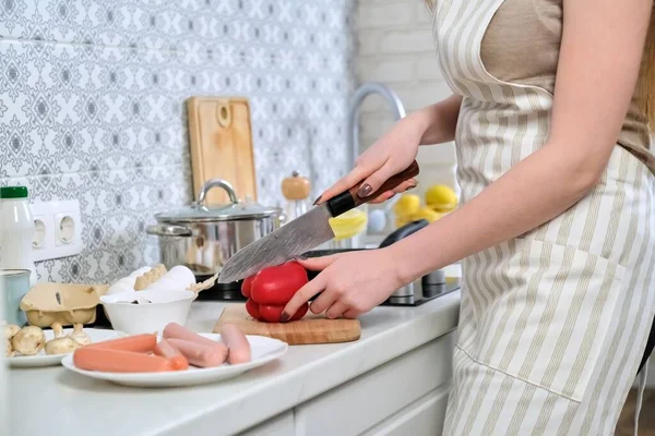 Close-up of womans hands cooking food in the kitchen, cutting paprika with knife — Stock Photo, Image