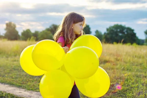 Portret van meisje met gele ballonnen, natuur hemel weide achtergrond — Stockfoto