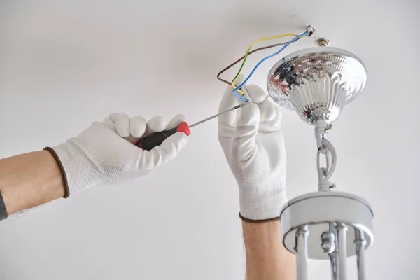 Instalação lâmpada de teto, mãos de eletricista fixando lustre — Fotografia de Stock