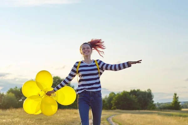 快乐的少女，带着气球在乡间小径上奔跑跳跃 — 图库照片