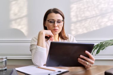 Kadın psikolog, psikiyatrist dijital tabletin web kamerasına bakıyor.