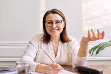 Kadın öğretmen, akıl hocası, psikolog dijital tabletin web kamerasına bakıyor.