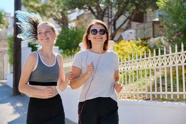 Active athletic family, mother and teenage daughter running together — Stock Photo, Image