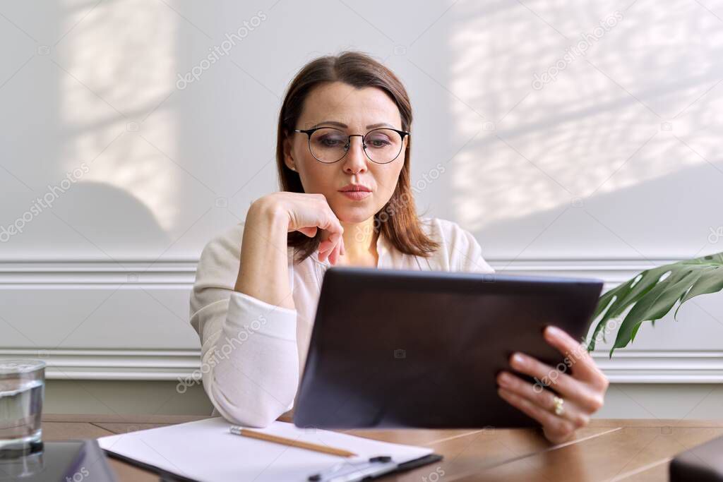 Female psychologist, psychiatrist looking at webcam of digital tablet