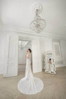 Güzel gelin gelinlik beyaz fotoğraf Studio poz. Ayna. Kanepe. Buket. Kapıyı. Avize.