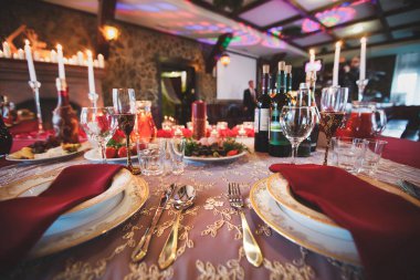 Çatal bıçak takımı ve bardak. Restoranda akşam yemeği. Mumlar masada. Ziyafet salonu. Düğün ziyafeti.