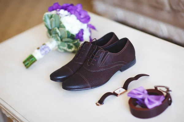 Scarpe da sposa, cinture, orologi e bouquet su una superficie bianca. Accessori per lo sposo il giorno del matrimonio . — Foto Stock