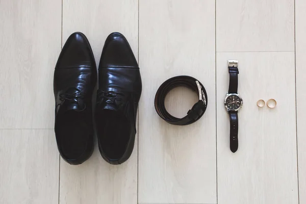 Accesorios para el novio el día de la boda. Relojes, anillos, cinturón, zapatos. La superficie de madera . — Foto de Stock