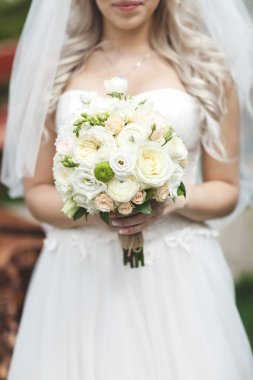 Gelin elinde güzel bir buket çiçek tutuyor. .