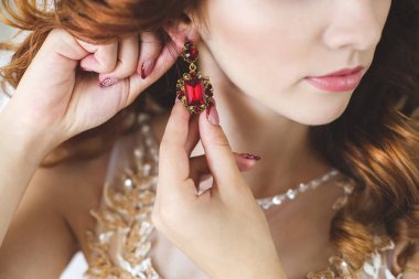 Kadın elinde küpeler, küpeler, gelin ücretleri, sabah gelini, beyaz elbise, küpe takıyor..