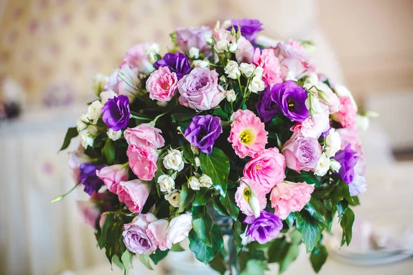 Kytice květin ve skleněné váze na svatebním stole — Stock fotografie