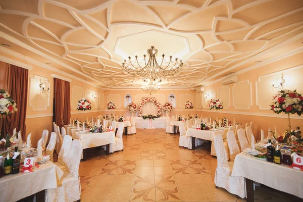 Hochzeitsbankettraum im Restaurant ist mit Blumen dekoriert. — Stockfoto