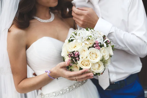 A menyasszony és a vőlegény egy esküvői csokor virágot tart.. — Stock Fotó